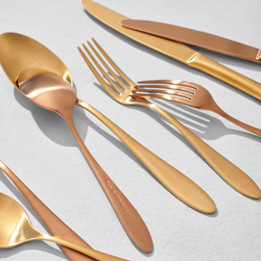 Mix of gold and copper flatware pieces