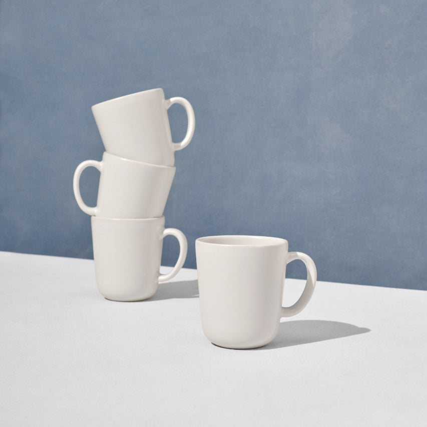 Grouping of four off white mugs