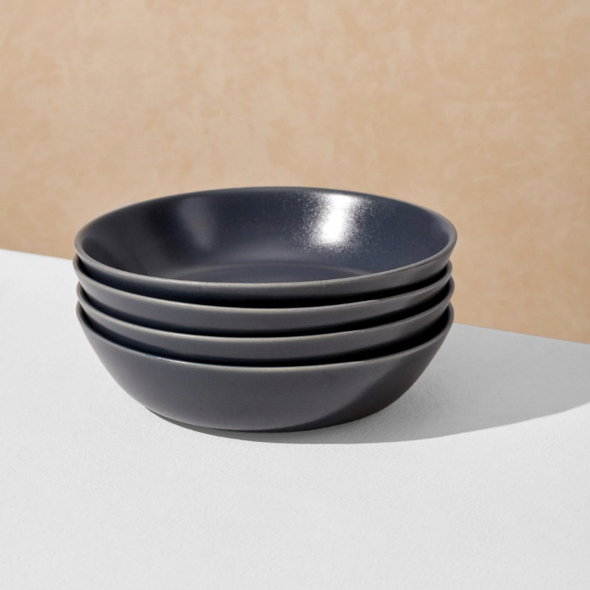 Stack of four charcoal navy pasta bowls